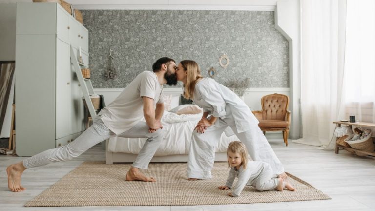 A family enjoying playful bonding moments in a stylish, minimalistic bedroom setting.