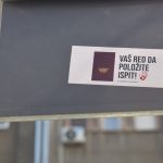 A sign with a sticker on it in front of a building